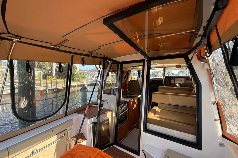 Slide: The Image of Interior view of 2022 Ranger Tugs R-27 boat, featuring seating and navigation area. - 27