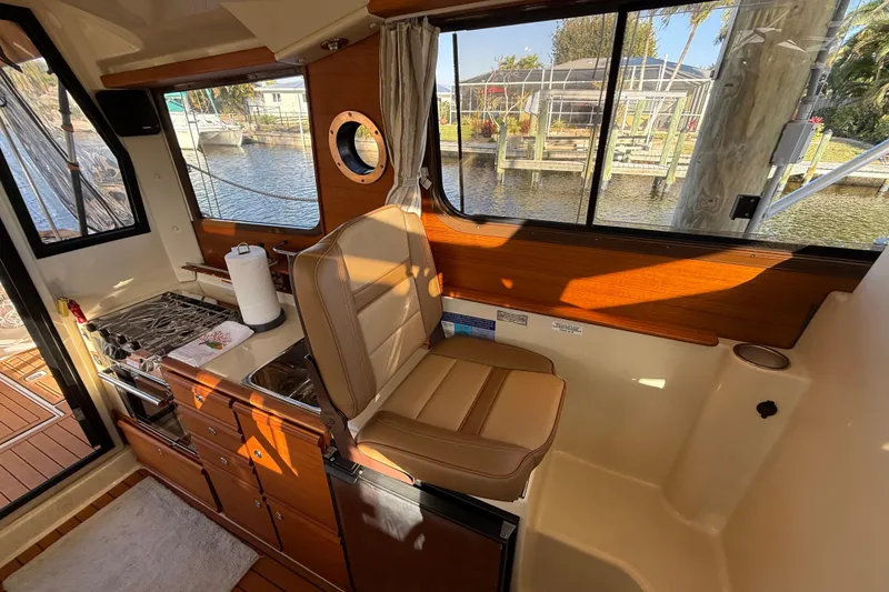 Slide: The Image of Interior of 2022 Ranger Tugs R-27 boat with kitchen and seating area. - 30