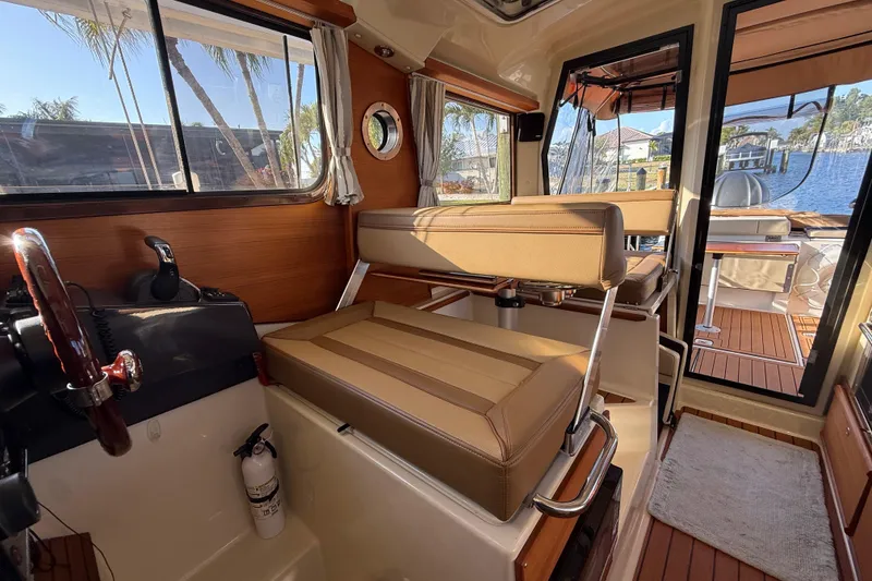 Slide: The Image of Interior of 2022 Ranger Tugs R-27 boat with seating and steering wheel. - 32