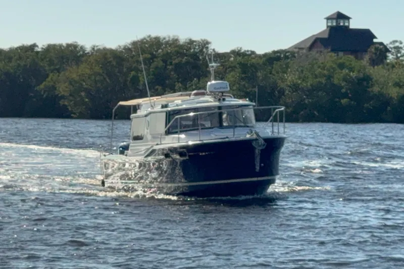 Slide: The Image of 2022 Ranger Tugs R-27 cruising on a scenic river with lush greenery. - 4