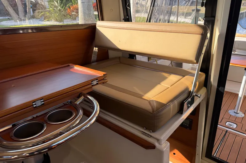 Slide: The Image of 2022 Ranger Tugs R-27 interior with foldable seat and wooden table. - 41