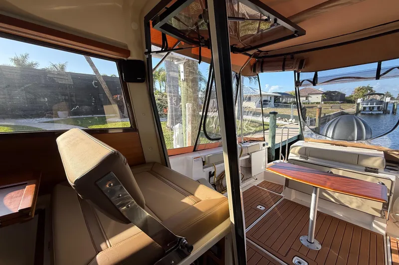 Slide: The Image of Interior of 2022 Ranger Tugs R-27 boat with seating and table, dockside view. - 42