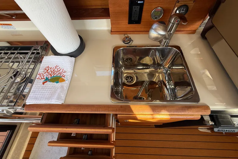 Slide: The Image of 2022 Ranger Tugs R-27 galley with stainless steel sink and decorative towel. - 46