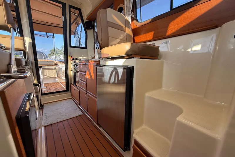 Slide: The Image of Interior of 2022 Ranger Tugs R-27 boat with wood accents and seating. - 48