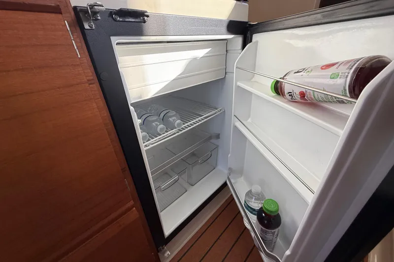 Slide: The Image of Refrigerator inside 2022 Ranger Tugs R-27 boat, stocked with beverages. - 49