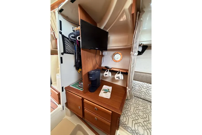 Slide: The Image of 2022 Ranger Tugs R-27 interior with TV, storage, and cozy seating area. - 56