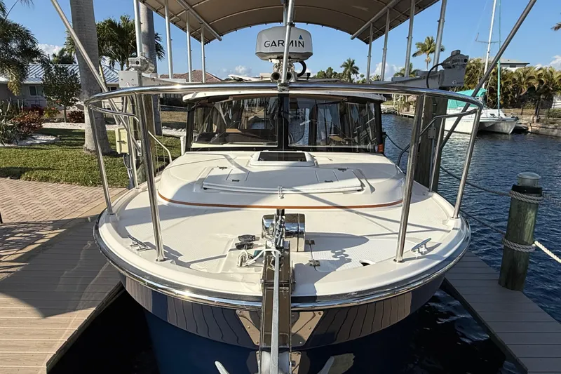 Slide: The Image of 2022 Ranger Tugs R-27 docked, featuring Garmin equipment, in a sunny waterfront setting. - 6