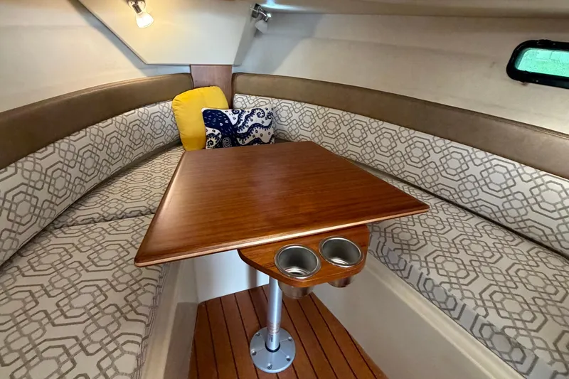 Slide: The Image of 2022 Ranger Tugs R-27 interior with patterned seating and wooden table. - 60