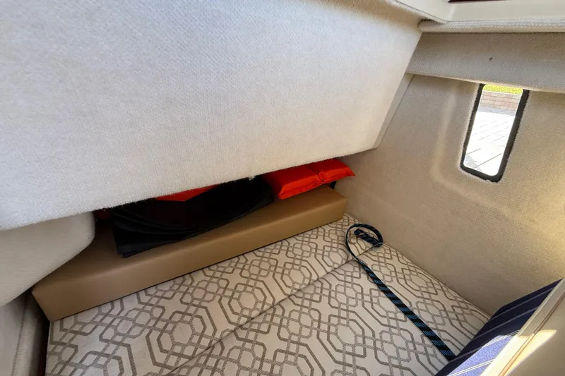 Slide: The Image of 2022 Ranger Tugs R-27 cabin interior with patterned cushions and storage space. - 62