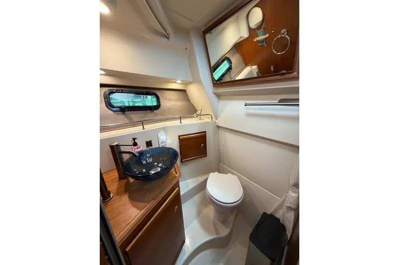 Slide: The Image of 2022 Ranger Tugs R-27 boat bathroom with modern sink, toilet, and mirror. - 64