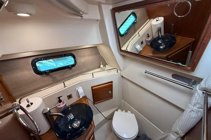 Slide: The Image of 2022 Ranger Tugs R-27 bathroom with modern sink, mirror, and window. - 65