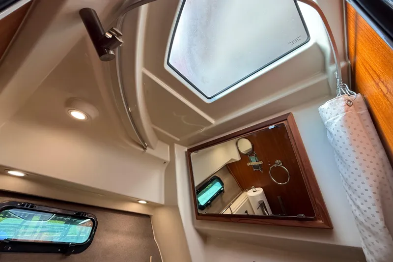 Slide: The Image of Interior of 2022 Ranger Tugs R-27 boat, featuring a skylight and modern bathroom amenities. - 67