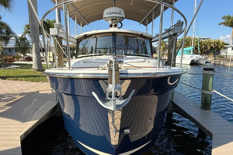 Slide: The Image of 2022 Ranger Tugs R-27 boat docked, featuring Garmin equipment, in a sunny marina setting. - 7