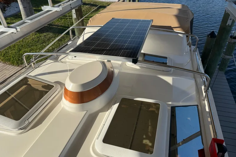 Slide: The Image of 2022 Ranger Tugs R-27 boat with solar panel on deck, docked by the water. - 72
