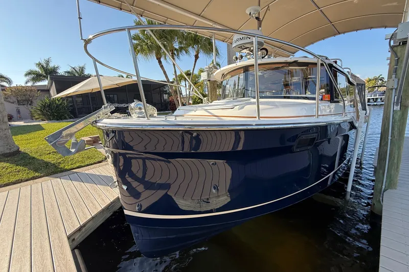Slide: The Image of 2022 Ranger Tugs R-27 boat docked under canopy, surrounded by tropical scenery. - 76