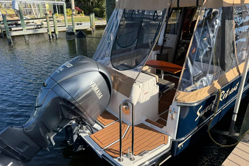 Slide: The Image of 2022 Ranger Tugs R-27 with Yamaha engine, docked, featuring a covered deck area. - 78