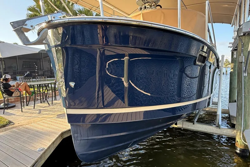 Slide: The Image of 2022 Ranger Tugs R-27 boat docked, blue hull, sunny day, waterfront setting. - 9