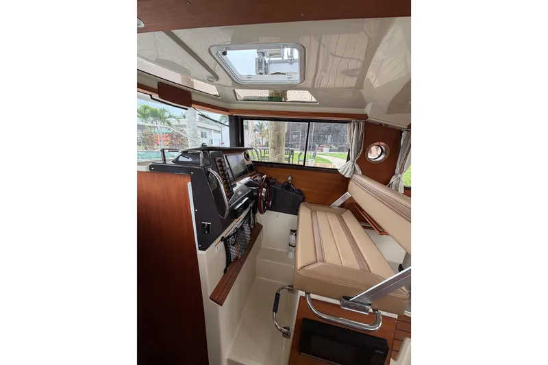 Slide: The Image of Interior of 2022 Ranger Tugs R-27 boat, featuring helm station and seating. - 90