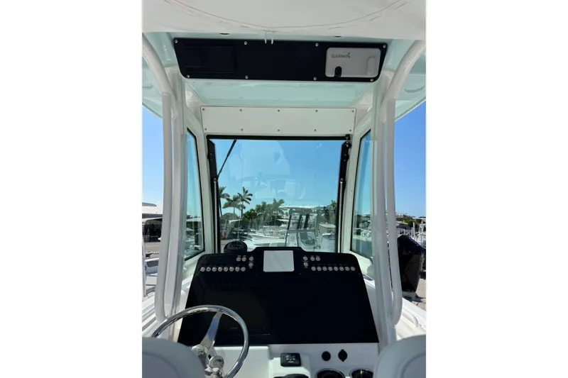 Slide: The Image of 2024 Everglades 235 Center Console boat dashboard with steering wheel and navigation equipment. - 10