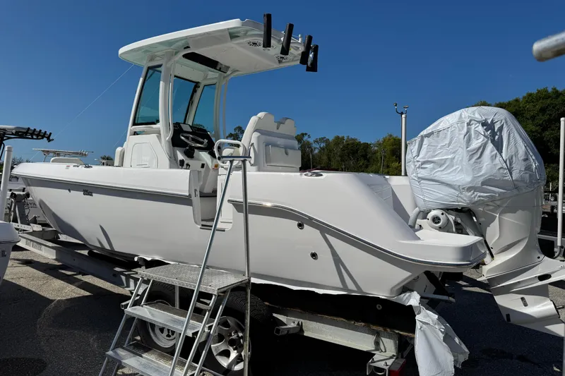 Slide: The Image of 2024 Everglades 235 Center Console boat on trailer, side view, under clear blue sky. - 3