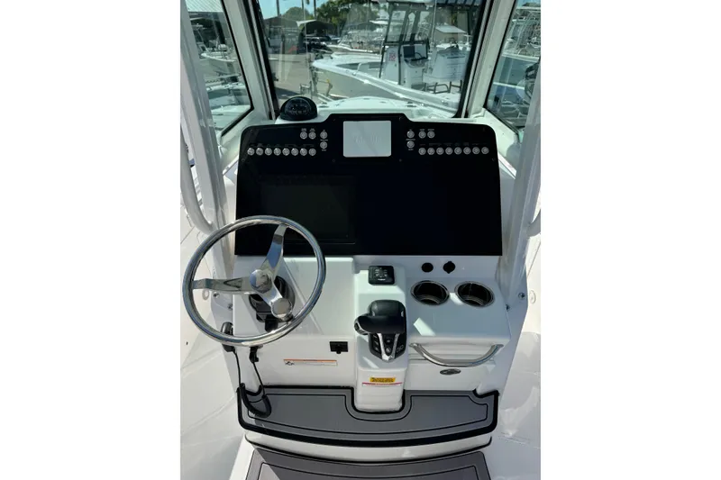 Slide: The Image of 2024 Everglades 235 Center Console boat dashboard with steering wheel and controls. - 9