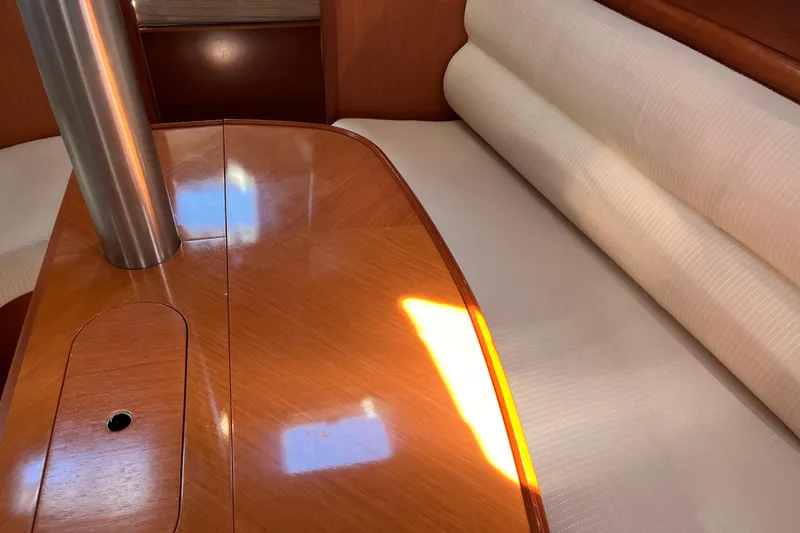 Slide: The Image of Interior of 2008 Beneteau Oceanis 343 sailboat with polished wood table and cushioned seating. - 44