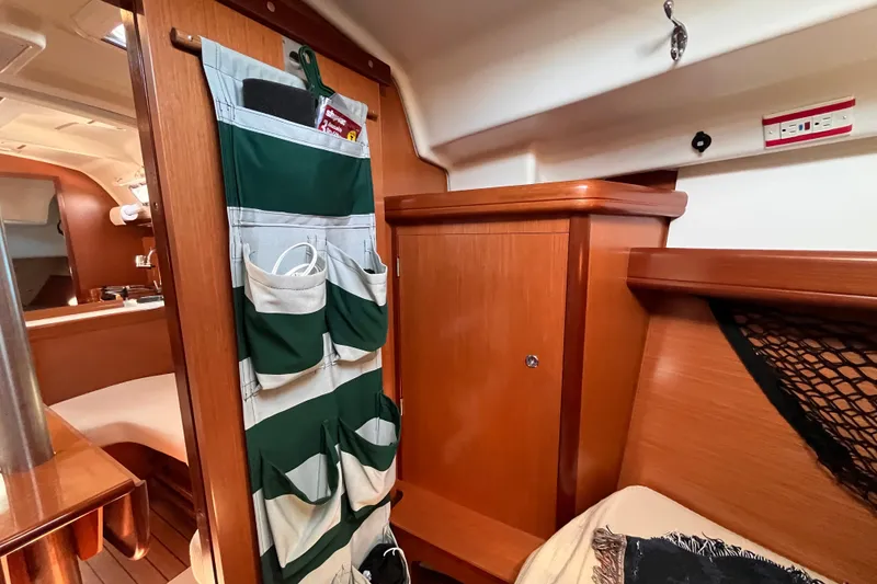 Slide: The Image of Interior of 2008 Beneteau Oceanis 343 sailboat with wooden cabinetry and storage pockets. - 47