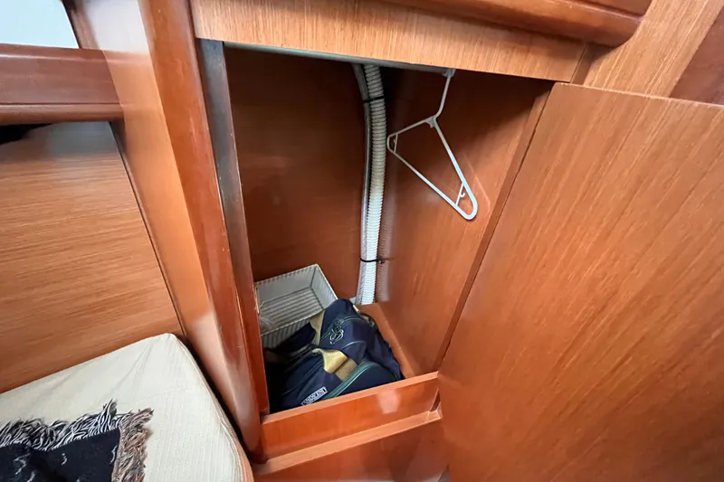Slide: The Image of Wooden closet interior on 2008 Beneteau Oceanis 343 sailboat, featuring a hanger and storage items. - 51