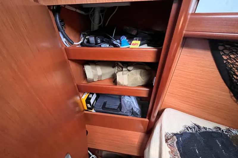 Slide: The Image of Storage shelves inside a 2008 Beneteau Oceanis 343 sailboat, holding various items. - 52