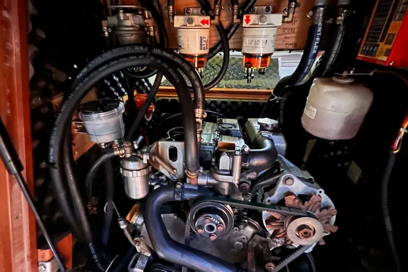 Slide: The Image of Engine compartment of a 2008 Beneteau Oceanis 343 sailboat, showcasing mechanical components and hoses. - 58