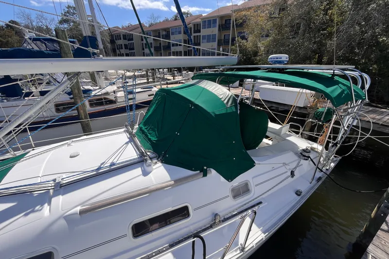 Slide: The Image of 2008 Beneteau Oceanis 343 sailboat docked, featuring green canopy and sleek white deck. - 6