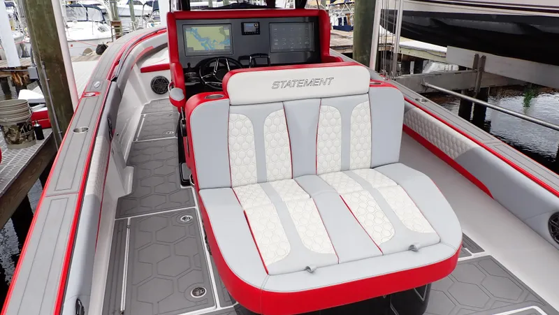 Slide: The Image of 2024 Statement 350 Open boat with red and white seating, docked at a marina. - 4