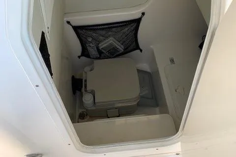 Slide: The Image of 2008 Century 2400 Center Console boat interior with portable toilet and storage net. - 15