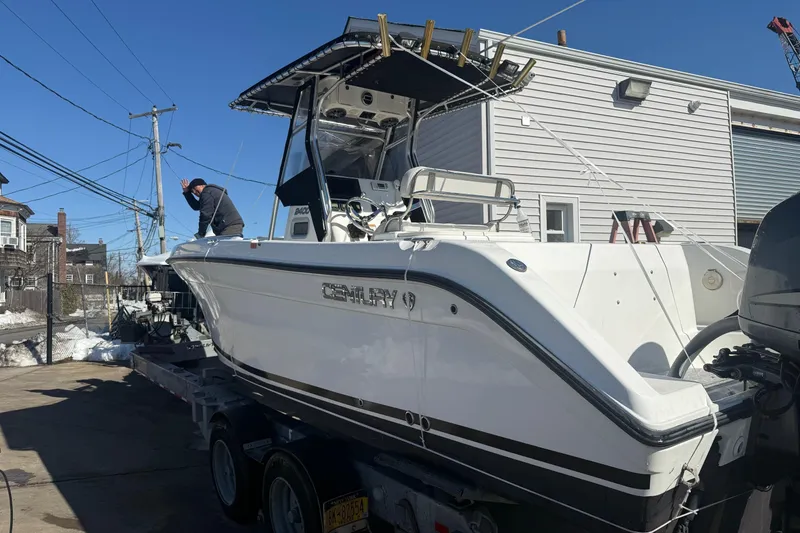 Slide: The Image of 2008 Century 2400 Center Console boat on trailer, parked outdoors under clear blue sky. - 19