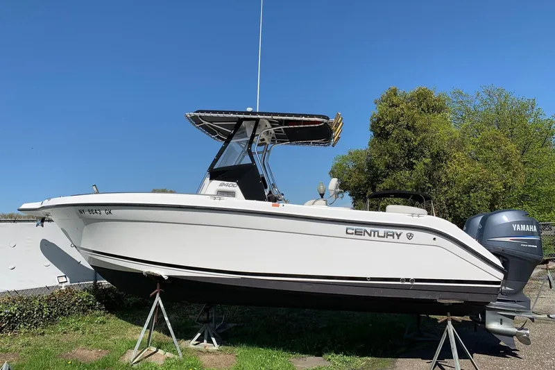 Slide: The Image of 2008 Century 2400 Center Console boat with Yamaha engine on stands, clear sky background. - 40