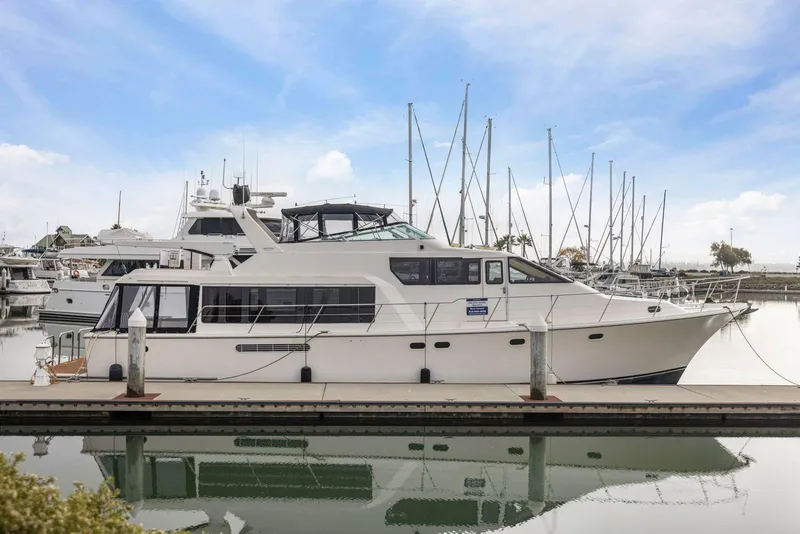 The Image of 1998 Pacific Mariner 65 yacht docked at marina, surrounded by sailboats under a clear sky. - 0