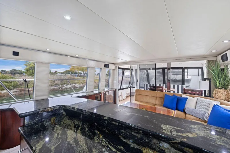 Slide: The Image of Luxurious interior of 1998 Pacific Mariner 65 yacht with elegant seating and panoramic windows. - 12