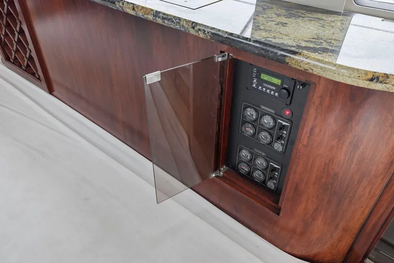 Slide: The Image of Control panel inside a 1998 Pacific Mariner 65 yacht with wooden cabinetry and glass door. - 15