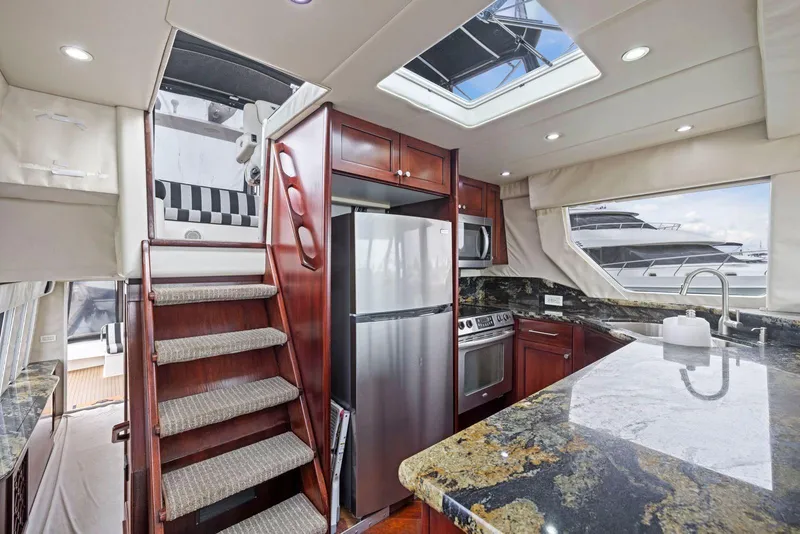 Slide: The Image of Luxurious 1998 Pacific Mariner 65 yacht interior with modern kitchen and elegant wood finishes. - 17