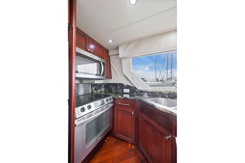 Slide: The Image of Luxurious kitchen interior of 1998 Pacific Mariner 65 yacht with modern appliances and wood cabinetry. - 19