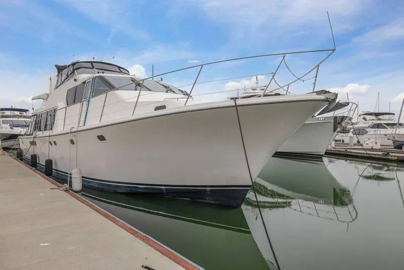 Slide: The Image of 1998 Pacific Mariner 65 yacht docked at marina under blue sky. - 2