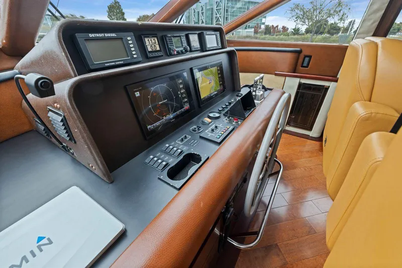 Slide: The Image of 1998 Pacific Mariner 65 yacht helm with navigation controls and leather seating. - 25