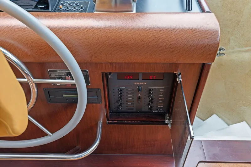 Slide: The Image of Control panel of a 1998 Pacific Mariner 65 yacht with steering wheel and switches. - 26