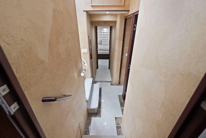 Slide: The Image of Interior hallway of a 1998 Pacific Mariner 65 yacht, featuring elegant beige walls and flooring. - 31