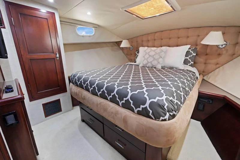 Slide: The Image of Luxurious bedroom interior of 1998 Pacific Mariner 65 yacht with elegant bedding and wood accents. - 38