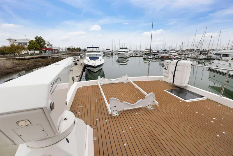 Slide: The Image of 1998 Pacific Mariner 65 yacht docked in a marina, featuring spacious deck and serene waters. - 55