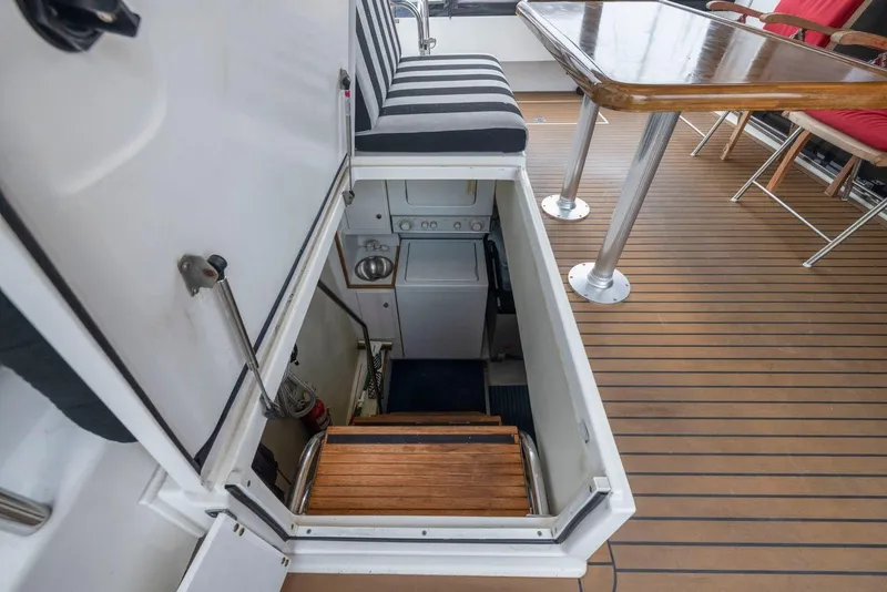 Slide: The Image of Laundry area on 1998 Pacific Mariner 65 yacht with striped seating and wooden table. - 58