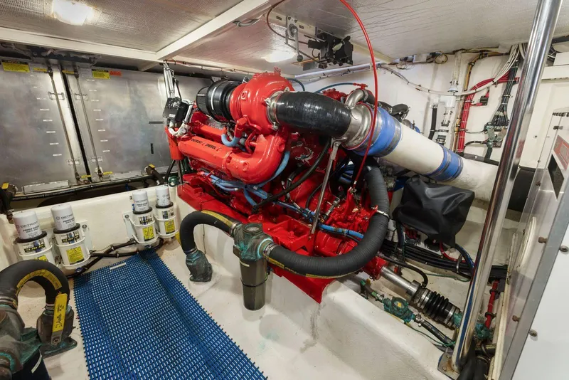Slide: The Image of Engine room of a 1998 Pacific Mariner 65 yacht, featuring a red engine and various components. - 61