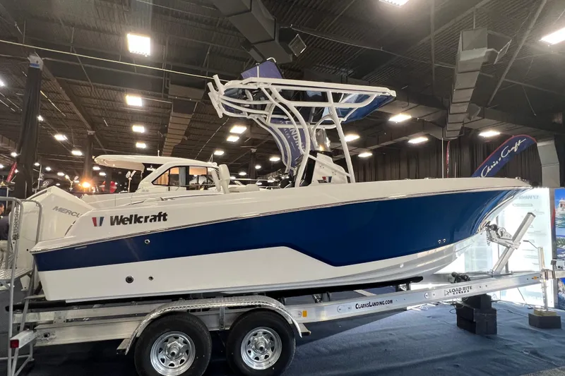 The Image of 2023 Wellcraft 222 Fisherman boat displayed indoors on a trailer. - 0