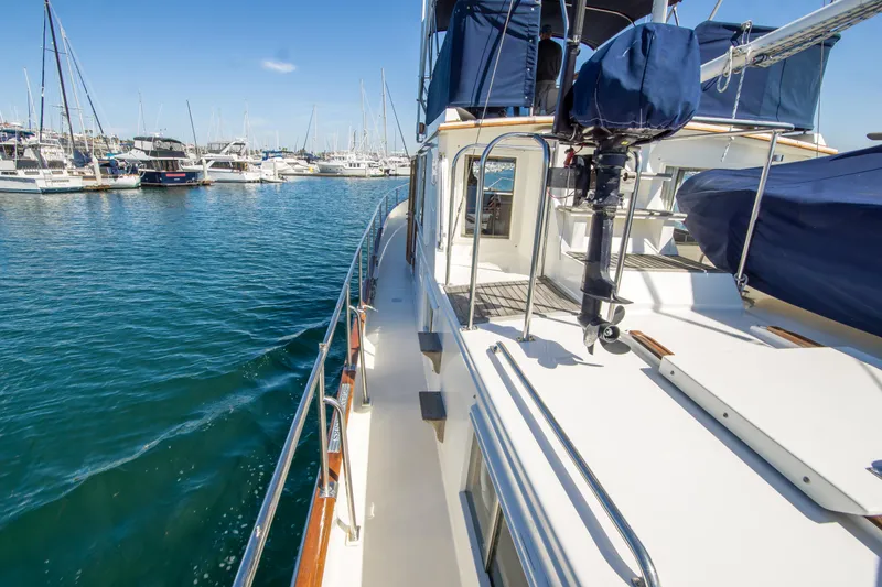 Slide: The Image of 1995 Grand Banks 42 Classic yacht docked in a marina, showcasing sleek deck design. - 11